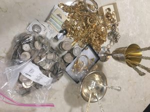 a different angle on the lot of silver coins and gold jewelry